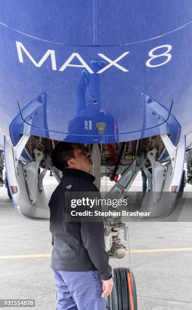 Boeing employees checks out the landing gear of a 737 MAX 8, after a celebration of the 10,000th 737 aircraft at the company's factory, on March 13,...