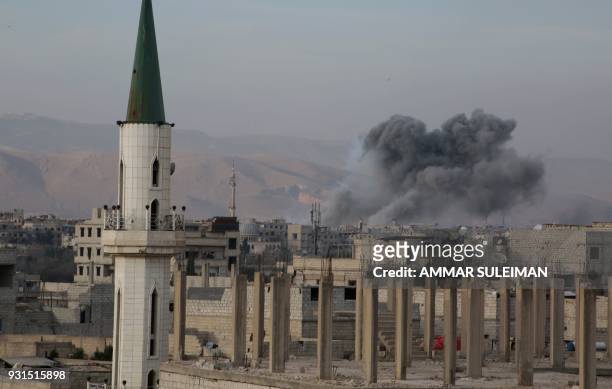 Smoke billows following government bombardment in Kafr Batna in the rebel-held enclave of Eastern Ghouta on March 13, 2018. A day earlier, the United...