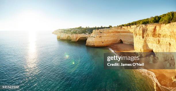 portuguese coast line with direct sunlight, benagil, portugal - cliff shore stock-fotos und bilder