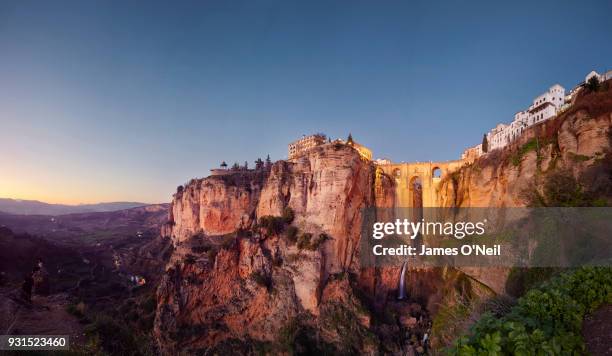 puente nuevo and the city of ronda at dusk, malaga, spain - spanish culture stock-fotos und bilder