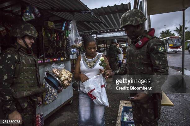 Solider distributes roses to celebrate International Women's Day in the Vila Kennedy neighborhood in Rio de Janeiro, Brazil, on Thursday, March 8,...