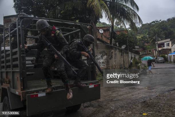 Soldiers exit a vehicle to patrol streets in the Vila Kennedy neighborhood in Rio de Janeiro, Brazil, on Thursday, March 8, 2018. As public safety...