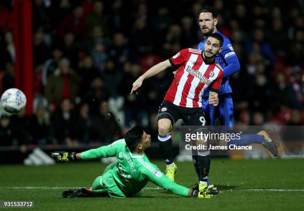 Neal Maupay of Brentford scores his sides first goal past Neil Etheridge of Cardiff City during the Sky Bet Championship match between Brentford and...