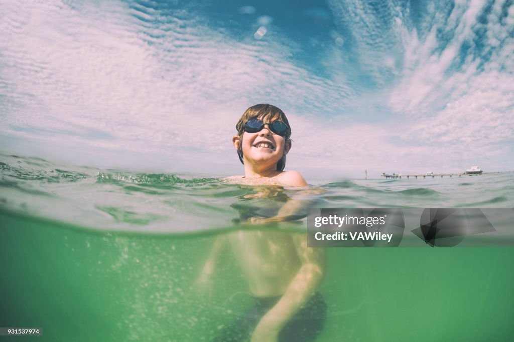 Junges Kind schwimmt im schönen grünen Gewässern von Florida