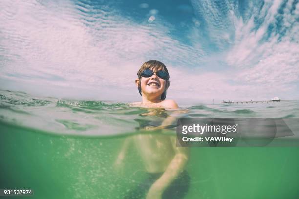 junges kind schwimmt im schönen grünen gewässern von florida - boy exploring on beach stock-fotos und bilder
