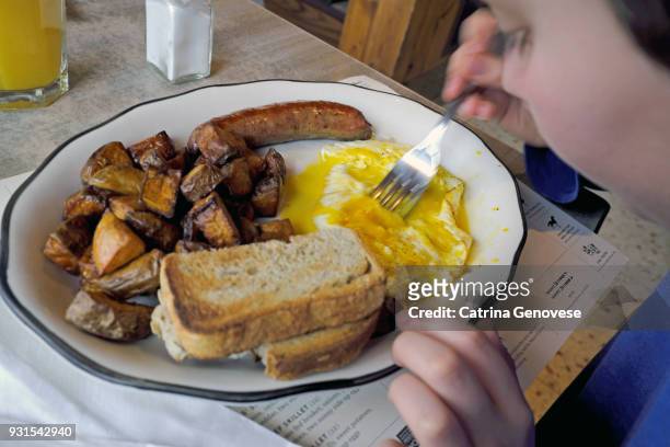 11 year old boy eating breakfast at diner - carbohydrate food type stock pictures, royalty-free photos & images