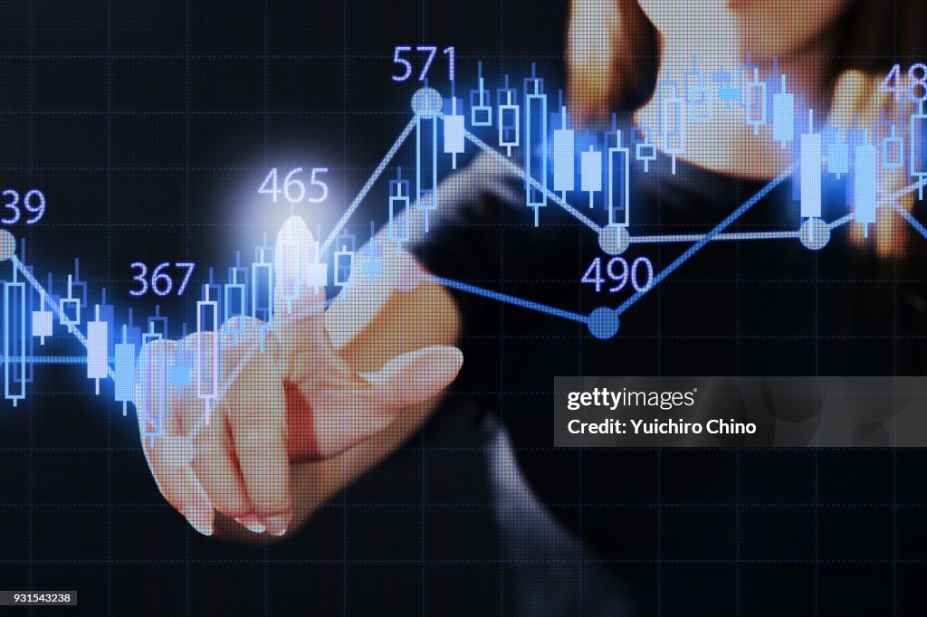 Woman pointing the stock market graph with virtual screen