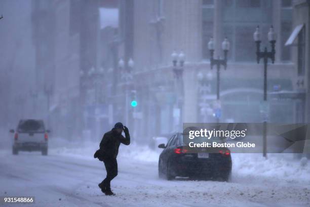 Man crosses Boylston Street near Copley Square in Boston during the third nor'easter storm to hit the region in two weeks on March 13, 2018.