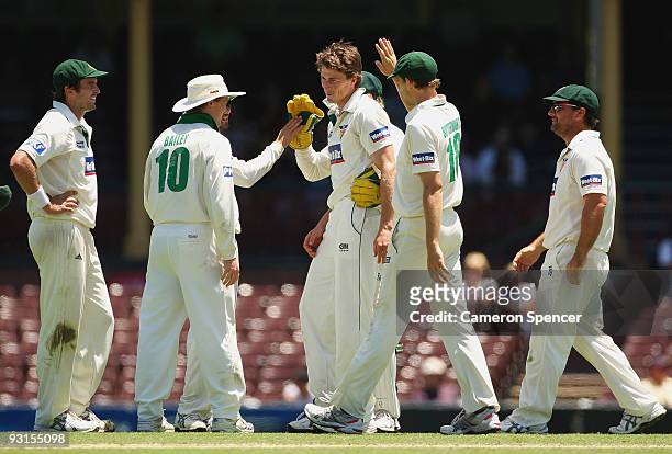 Brendan Drew of the Tigers is congratulated by team mates after dismissing Usman Khawaja of the Blues during day two of the Sheffield Shield match...