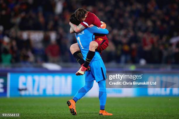 Alisson of AS Roma celebrates with teammate Daniele De Rossi after his side scored the opening goal during the UEFA Champions League Round of 16...