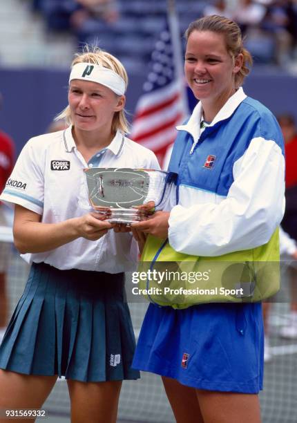 Jana Novotna of the Czech Republic and Lindsay Davenport of the USA pose with the trophy after defeating Gigi Fernandez of the USA and Natasha...