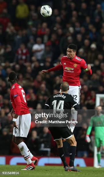 Chris Smalling of Manchester United in action with Guido Pizarro of Sevilla FC during the UEFA Champions League Round of 16 Second Leg match between...