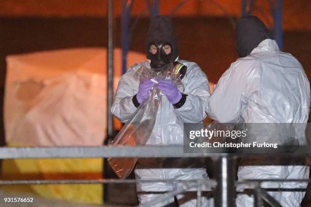 Police officers in forensics suits and protective masks work at the scene of the poisoning of Sergei Skripal on March 13, 2018 in Salisbury, England....