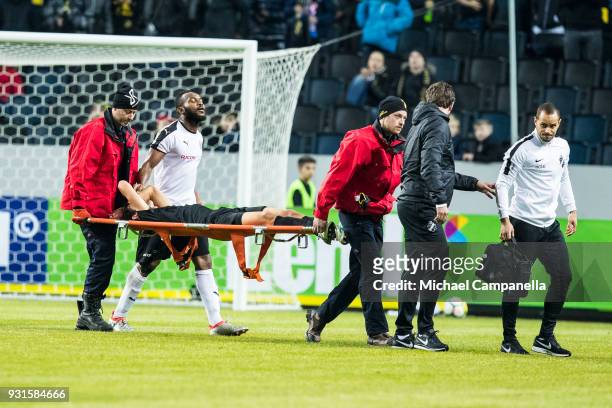 Jesper Nyholm of AIK is carried out on a stretcher after being injured by Michael Omoh of Orebro SK during a Swedish Cup quarter final match between...