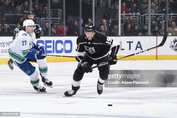 Alex Iafallo of the Los Angeles Kings skates after the puck against Ben Hutton of the Vancouver Canucks at STAPLES Center on March 12, 2018 in Los...
