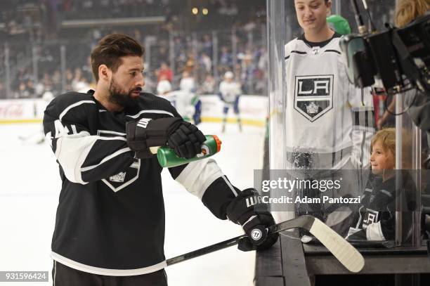 Nate Thompson of the Los Angeles Kings interacts with a fan before a game against the Vancouver Canucks at STAPLES Center on March 12, 2018 in Los...