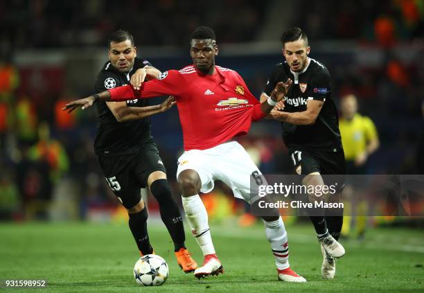Paul Pogba of Manchester United battles with Gabriel Mercado and Pablo Sarabia of Sevilla during the UEFA Champions League Round of 16 Second Leg...