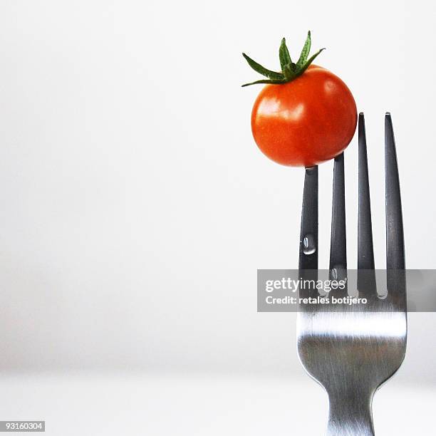 cherry tomato on fork - retales botijero fotografías e imágenes de stock