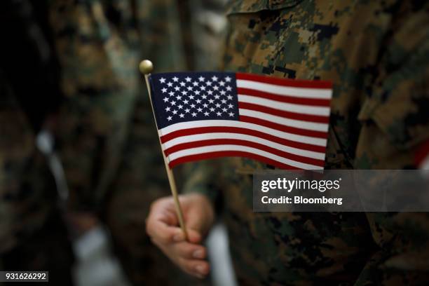 An attendee holds an American flag after an event with U.S. President Donald Trump, not pictured, at Marine Corps Air Station Miramar in San Diego,...