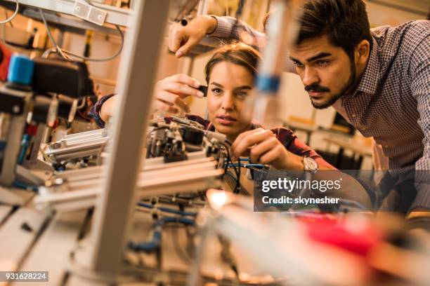 two engineering students working on electrical component of a machine in laboratory. - stem assunto imagens e fotografias de stock