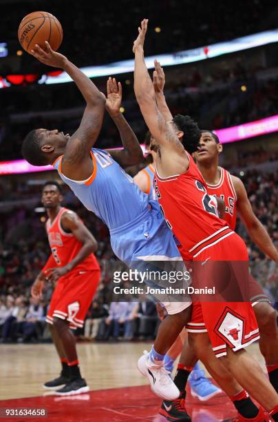 Jawun Evans of the LA Clippers tries to get off a shoit against Cameron Payne of the Chicago Bulls at the United Center on March 13, 2018 in Chicago,...