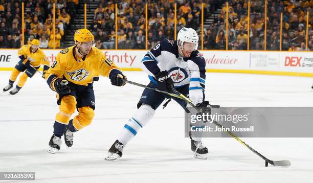 Calle Jarnkrok of the Nashville Predators is called for hooking against Andrew Copp of the Winnipeg Jets during an NHL game at Bridgestone Arena on...