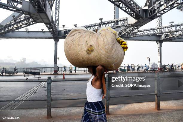 Local man seen carrying goods on top of his head on the Howrah bridge in Kolkata. The Rabindra Setu also known as the Howrah bridge is a bridge with...