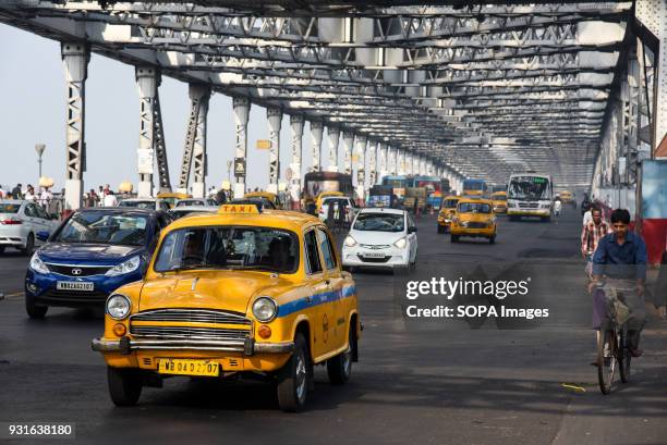 Local taxi seen running on the Howrah bridge in Kolkata. The Rabindra Setu also known as the Howrah bridge is a bridge with a suspended span over the...