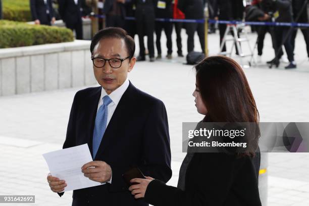 Lee Myung-bak, South Korea's former president, left, speaks as he arrives at the Seoul Central District Prosecutors Office in Seoul, South Korea, on...