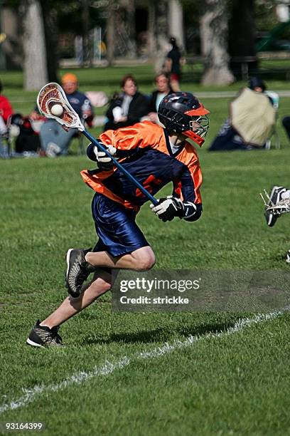 männliche lacrosse-spieler in blau und orange springs, action attack - lacrosse stock-fotos und bilder