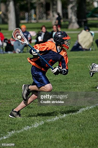 macho jogador de lacrosse em azul laranja de ataque a acção - lacrosse imagens e fotografias de stock