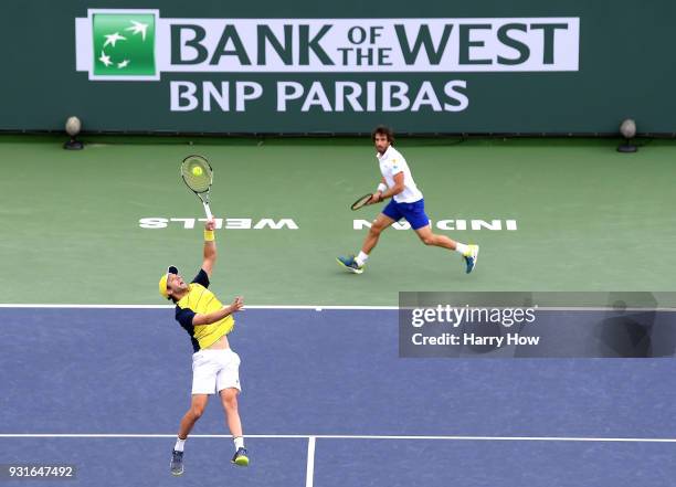 Horacio Zeballos of Argentina plays an overhaed in front of Pablo Cuevas of Uruguay in their match against Pierre-Hugues Herbert and Nicolas Mahut of...