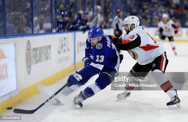 Cedric Paquette of the Tampa Bay Lightning and Tom Pyatt of the Ottawa Senators fight for the puck during a game at Amalie Arena on March 13, 2018 in...