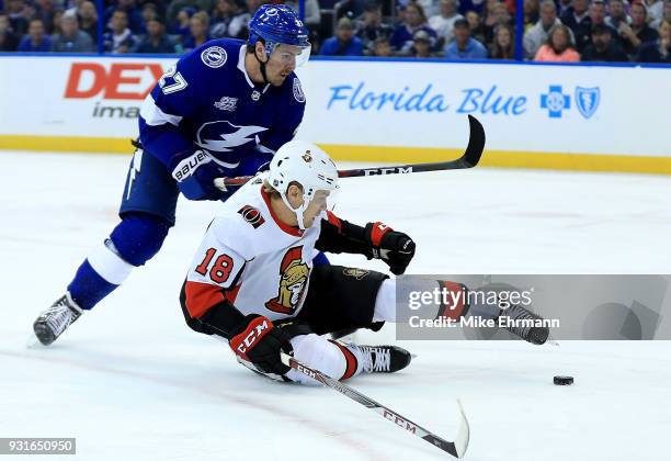 Ryan McDonagh of the Tampa Bay Lightning and Ryan Dzingel of the Ottawa Senators fight for the puck during a game at Amalie Arena on March 13, 2018...