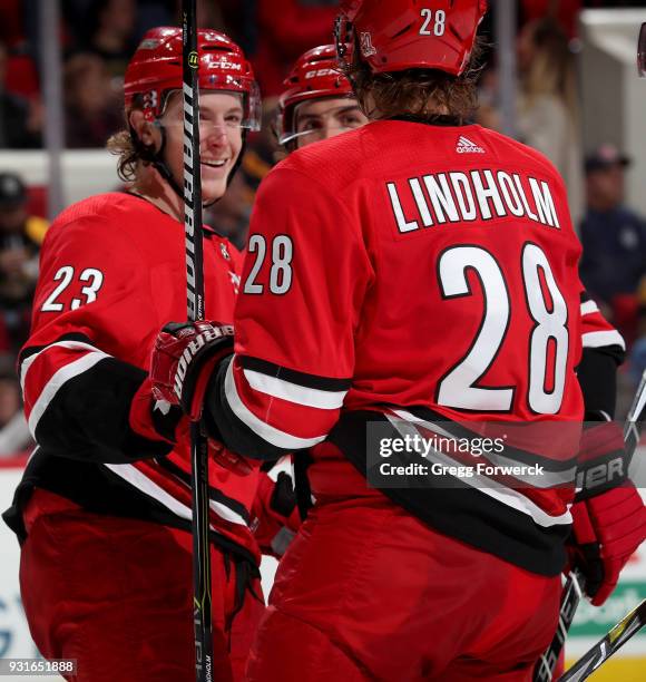 Brock McGinn of the Carolina Hurricanes is congratulated by teammate Elias Lindholm after scoring a short handed goal during an NHL game against the...