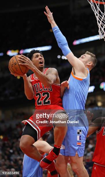 Cameron Payne of the Chicago Bulls goes up for a shot against Sam Dekker of the LA Clippers at the United Center on March 13, 2018 in Chicago,...