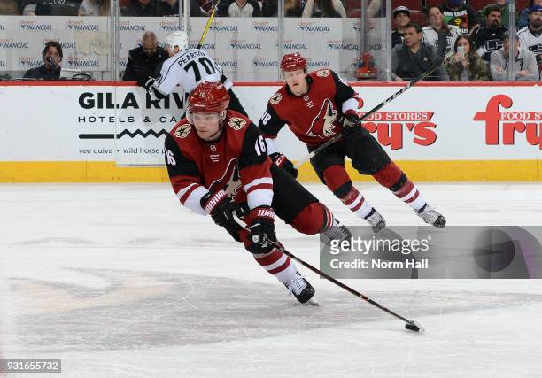 Max Domi of the Arizona Coyotes advances the puck up ice ahead of teammate Christian Dvorak during the first period against the Los Angeles Kings at...