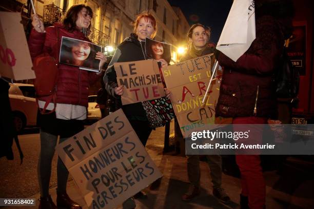 Women from feminist organizations holding photos of late French actress Marie Trintignant and placards reading "If killing is an art, award Cantat...