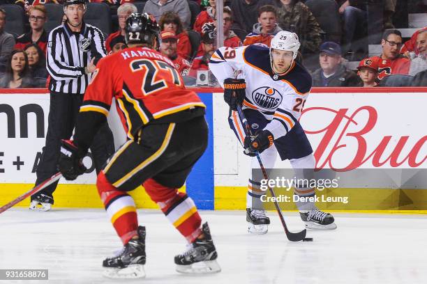 Dougie Hamilton of the Calgary Flames defends against Leon Draisaitl of the Edmonton Oilers during an NHL game at Scotiabank Saddledome on March 13,...