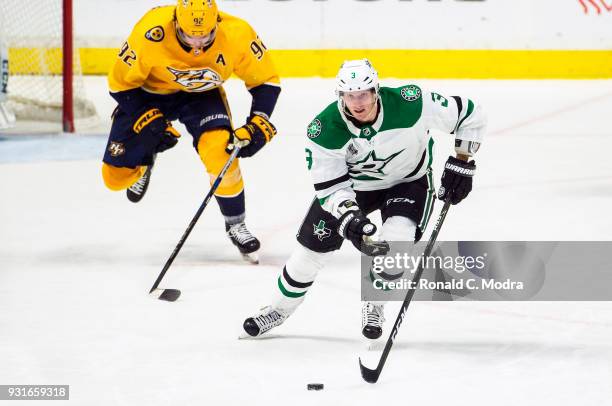 John Klingberg of the Dallas Stars skates against Ryan Johansen of the Nashville Predators during an NHL game at Bridgestone Arena on March 6, 2018...