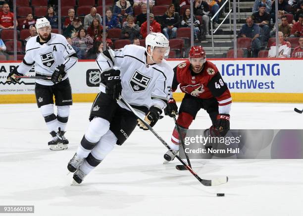 Dion Phaneuf of the Los Angeles Kings skates with the puck ahead of Jordan Martinook of the Arizona Coyotes during the first period at Gila River...
