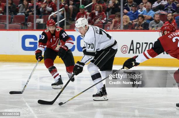 Tanner Pearson of the Los Angeles Kings skates with the puck between Alex Goligoski and Derek Stepan of the Arizona Coyotes during the second period...