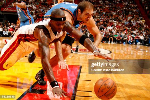 Jermaine O'Neal of the Miami Heat battles for a loose ball against Nenad Krstic of the Oklahoma City Thunder on November 17, 2009 at American...