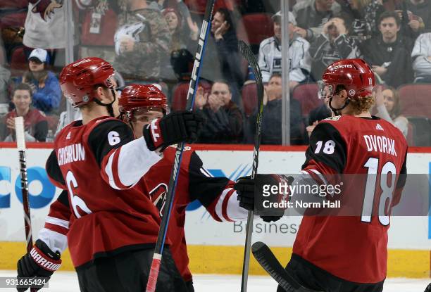 Christian Dvorak of the Arizona Coyotes celebrates with teammates Jakob Chychrun and Max Domi after his second period goal against the Los Angeles...