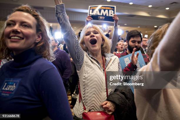Attendees cheer as election numbers are reported during an election night rally for Conor Lamb, Democratic candidate for the U.S. House of...