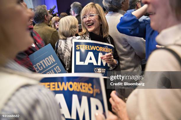 Attendees hold "Steelworkers for Lamb" signs during an election night rally for Conor Lamb, Democratic candidate for the U.S. House of...