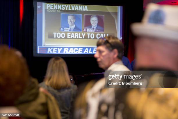 Television screen displays a graphic that reads "Too Early To Call" during an election night rally for Conor Lamb, Democratic candidate for the U.S....