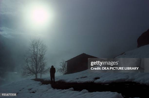 Man walking in a snowy landscape in Bergamo, Lombardy, Italy.