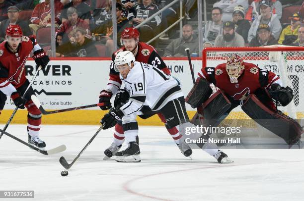 Alex Iafallo of the Los Angeles Kings tries to gain control of the puck in front of Oliver Ekman-Larsson and goalie Adin Hill of the Arizona Coyotes...