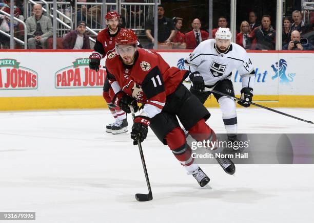 Brendan Perlini of the Arizona Coyotes advances the puck up ice ahead of Nate Thompson of the Los Angeles Kings during the third period at Gila River...